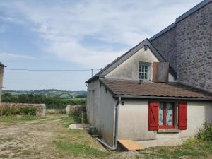 a small house with red doors and a window at Chez Norbert in Quarré-les-Tombes