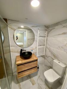 ein Badezimmer mit Toilette, Waschbecken und Spiegel in der Unterkunft Villa Maca in Pontevedra