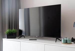 a large flat screen tv sitting on top of a white cabinet at Casa Eolo Mare e Relax in Lido di Jesolo