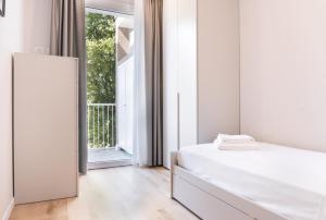 a white bedroom with a bed and a window at Casa Eolo Mare e Relax in Lido di Jesolo +22 photos