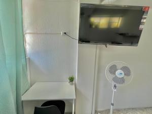 a white room with a fan and a window at Urban Hotel in Guatemala