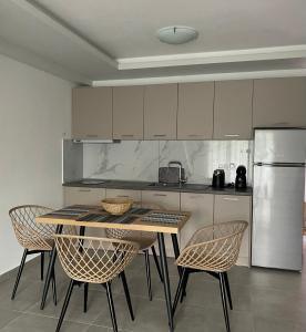 a kitchen with a table and chairs and a refrigerator at Margarita's apartment 4 in Nea Peramos +17 photos