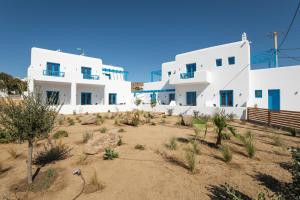 a view of two white buildings in the desert at Corfos Pearl Studios in Ornos