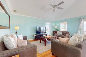 a living room with two couches and a flat screen tv at Pelican Perch in Dauphin Island