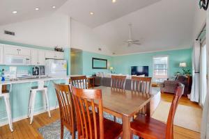 a kitchen and living room with a wooden table and chairs at Pelican Perch in Dauphin Island