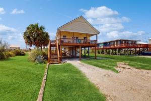 a house with a deck and a staircase leading to it at Pelican Perch in Dauphin Island