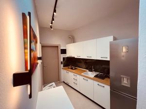 a kitchen with white cabinets and a stainless steel refrigerator at Selena Boutique in Neos Marmaras