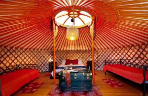 a room with two beds and a suitcase in a yurt at Yurte in Langa in Bosia
