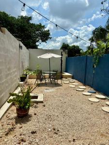 a patio with an umbrella and a table and chairs at Casa Ufemia in Mérida