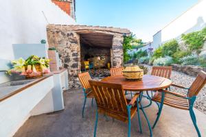 a wooden table and chairs on a patio at Domo Bangone - Sa Corte in Orosei