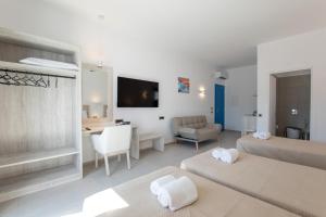 a bedroom with two beds and a living room at Corfos Pearl Studios in Ornos