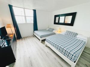 a bedroom with two beds and a television in it at Miami Hollywood Condo With Pool and Partial Ocean View 003-21mar in Hollywood +22 photos
