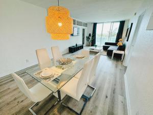 a dining room with a glass table and white chairs at Miami Hollywood Condo With Pool and Partial Ocean View 003-21mar in Hollywood