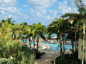 a view of a pool with palm trees and a resort at Miami Hollywood Condo With Pool and Partial Ocean View 003-21mar in Hollywood