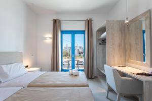 a bedroom with a bed and a desk with a view at Corfos Pearl Studios in Ornos
