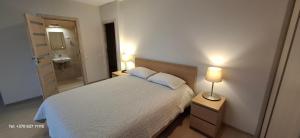 a bedroom with a bed and a bathroom with a sink at Šventojoje Parko 10 in Palanga