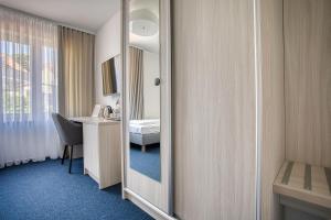 a bathroom with a mirror and a sink and a desk at Willa Z Widokiem na Jezioro in Ryn +18 photos