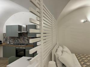 オルトーナにあるCasetta La Ritornaのリビングルームに螺旋階段付きのキッチン