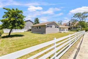 a white fence in front of a house at AC Beach Farmhouse Retreat - 5BD 2BA in Atlantic City