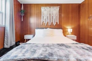 a bedroom with a large bed with wooden walls at AC Beach Farmhouse Retreat - 5BD 2BA in Atlantic City