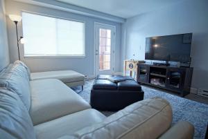 a living room with a couch and a flat screen tv at Game Room, Heated Pool, Hot Tubs, Private Washer Dryer in Steamboat Springs