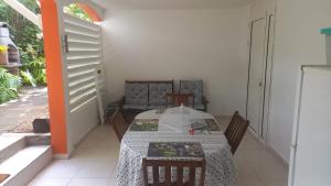 ein Esszimmer mit einem Tisch, einem Tisch und Stühlen in der Unterkunft bungalow ti dauphin rdc in Sainte-Anne