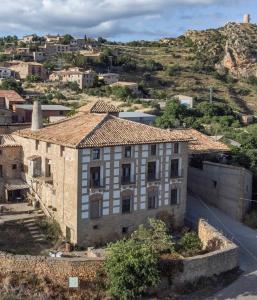un vecchio edificio in pietra su una collina con una strada di Casa Calvo SXVI a Santa Eulalia la Mayor