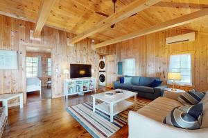 a living room with a couch and a tv at Sunflower Cottage in Freeport