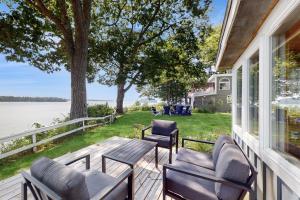 a porch with chairs and a table and a view of the water at Sunflower Cottage in Freeport