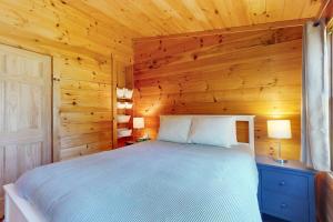 a bedroom with a bed in a wooden room at Sunflower Cottage in Freeport