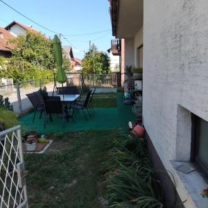 a patio with a table and chairs in a yard at Dijana Gloria in Zadvorsko