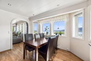 a dining room with a table and chairs and windows at Villa Valentina in Alta