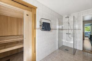 a bathroom with a shower with a glass door at Villa Valentina by Arctic Prive - Northern Lights Villa with Sauna & Fjord View in Alta in Alta +57 photos