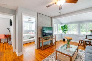 a living room with a couch and a television and a table at Jacksonville Apartment with Private Patio Near NAS! in Jacksonville