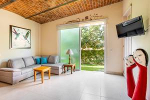 a living room with a couch and a tv at Villas San Juan Cosala in San Juan Cosalá