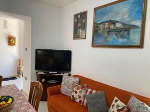 a living room with a couch and a flat screen tv at Lemon House in Sassari