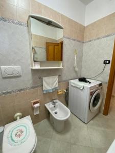 a bathroom with a toilet sink and a washing machine at Lemon House in Sassari +37 photos