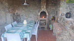 comedor con mesa y horno de piedra en Casa in roccaforte Longobarda, en Bagni di Lucca