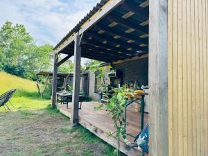 a wooden pergola with a table and chairs on a deck at Bell tent Boven Duin in 't Horntje
