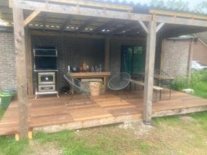 a wooden deck with a table and a stove at Bell tent Boven Duin in 't Horntje +6 photos