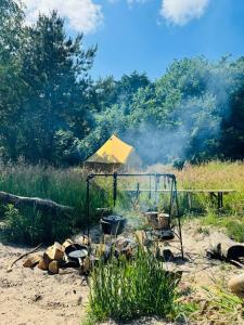 a grill in a field with a fire at Bell tent Boven Duin in 't Horntje