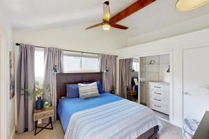 a bedroom with a blue bed and a ceiling fan at Jewel by the Sea in Cambria