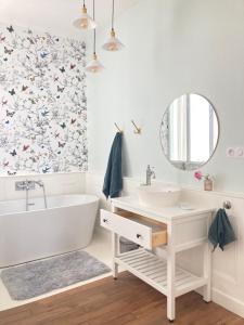 Un baño con bañera, lavabo y espejo. en Le Jardin Des Délices charming house in Troyes, en Troyes 38 fotos más
