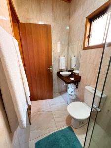 a bathroom with a toilet and a sink at Pousada Shangri-lá in Cunha