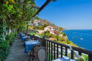 a row of tables and chairs on a balcony overlooking the ocean at Hotel Costa Diva in Praiano