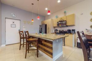 a kitchen with a counter and chairs in a room at La Isla Condominiums #C105 in South Padre Island