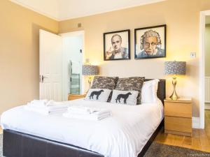 a bedroom with a large white bed with pictures on the wall at Alum Chine Beach House in Bournemouth