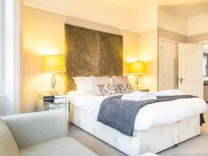 a bedroom with a large bed with two lamps and a couch at Alum Chine Beach House in Bournemouth