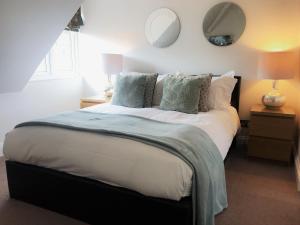 a bedroom with a large white bed with pillows at Alum Chine Beach House in Bournemouth