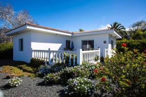 a white house with a white fence and flowers at Los Guanches Bungalows in El Paso
